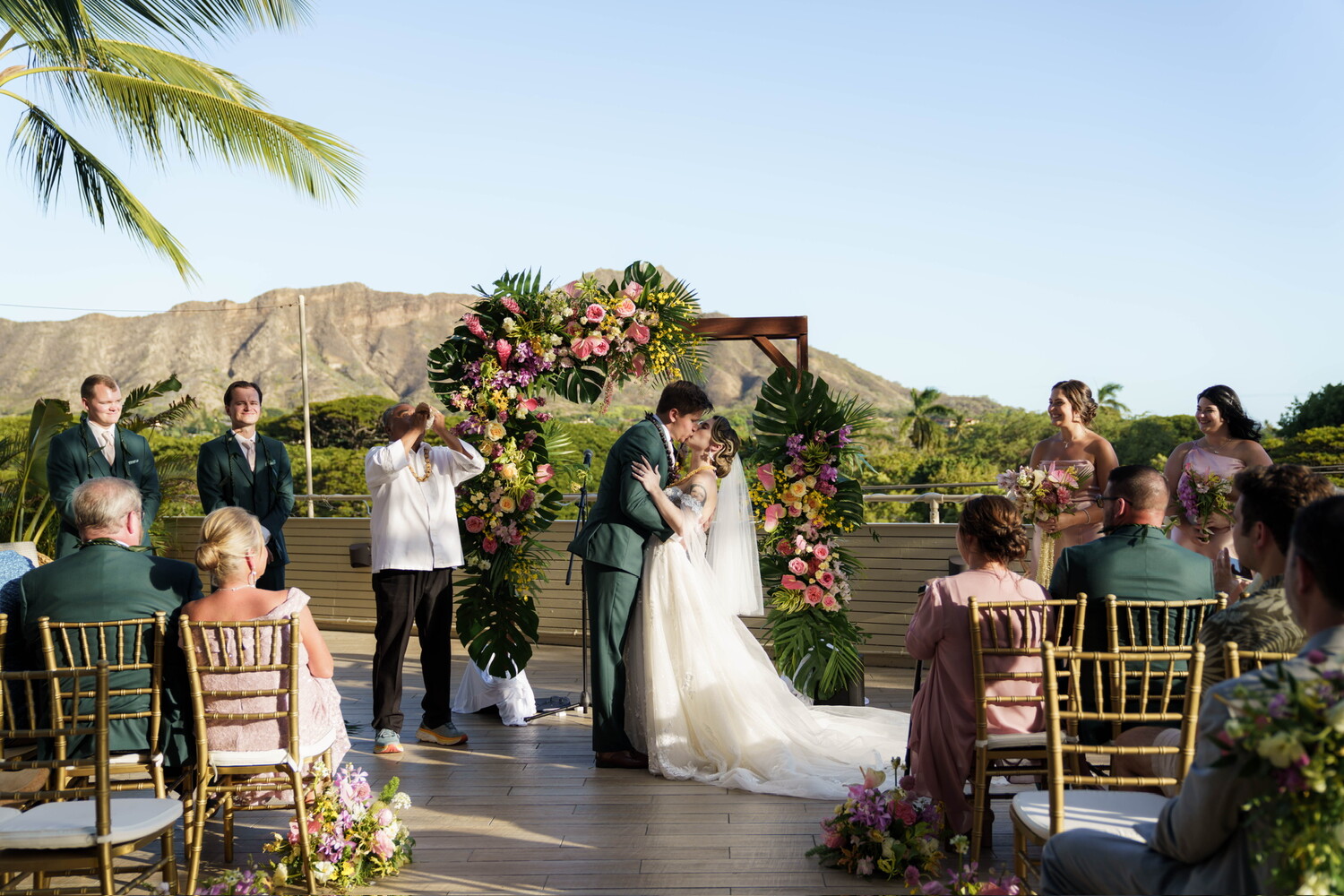 a man and woman kissing under a floral arch