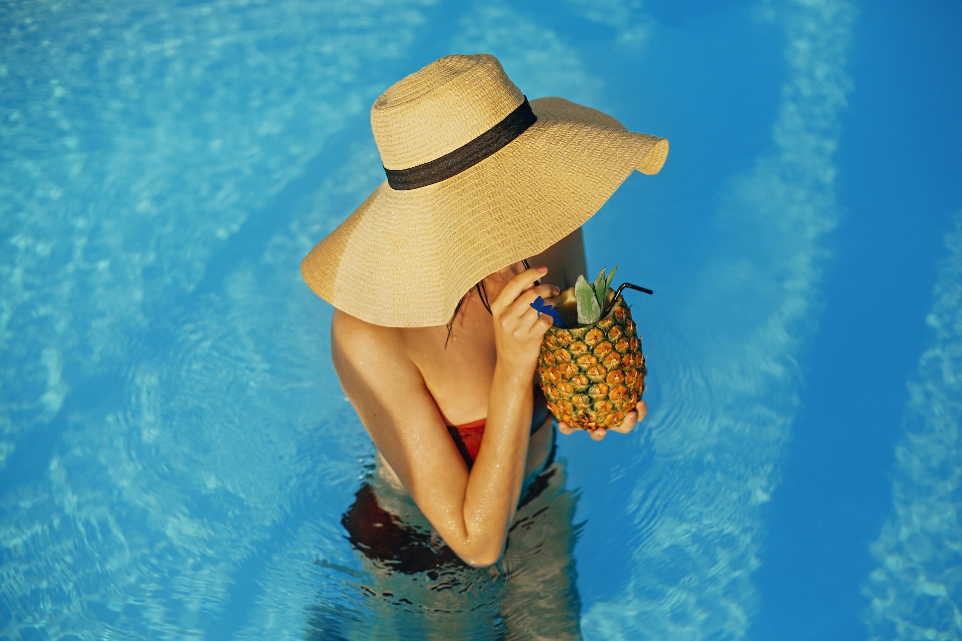 woman drinking by the pool