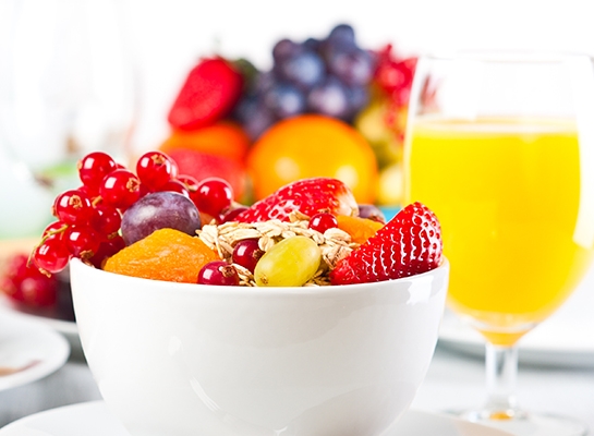 Delicious bowl of fruit and glass of orange juice